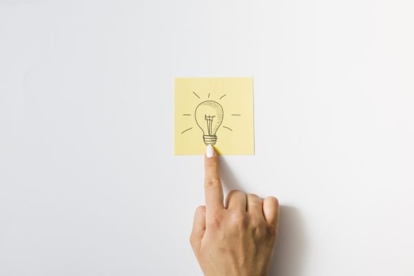 close-up-person-touching-finger-drawn-light-bulb-sticky-note_Easy-Resize.com
